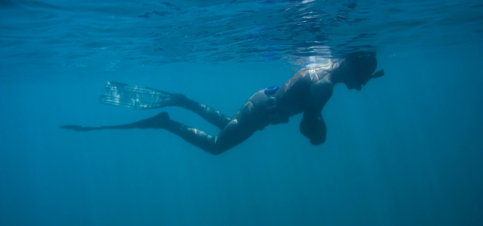 man in black shorts swimming in water